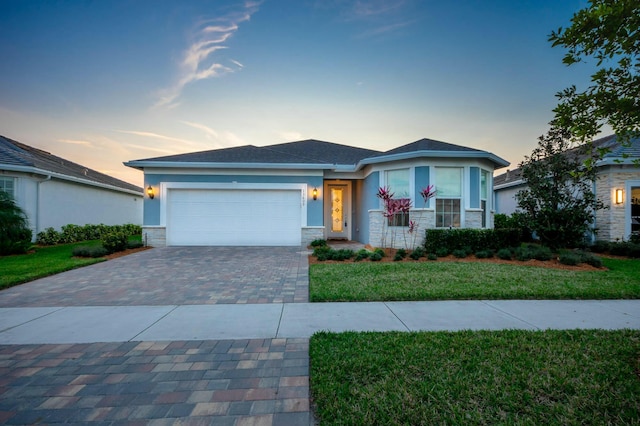 ranch-style house featuring a garage and a yard