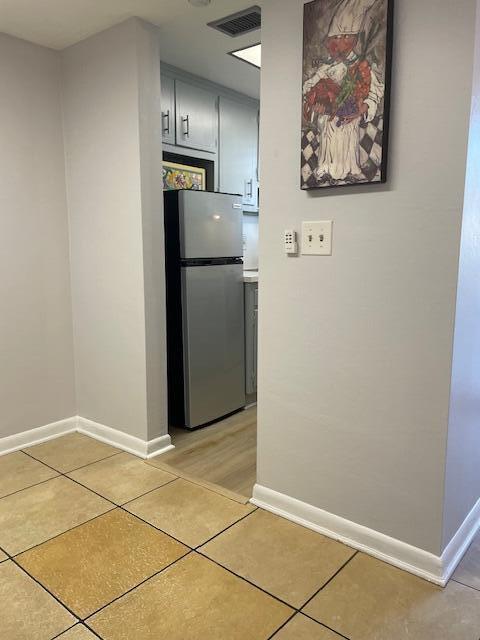 kitchen featuring light tile patterned floors and stainless steel refrigerator