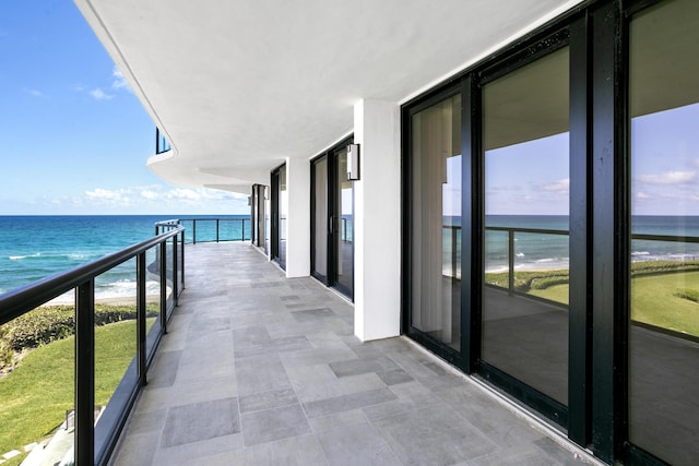 balcony featuring a water view and a beach view