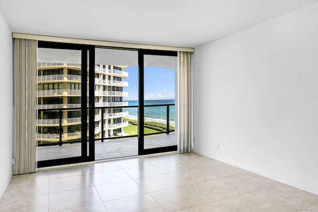 tiled empty room with floor to ceiling windows and a water view