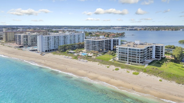 birds eye view of property with a water view and a beach view