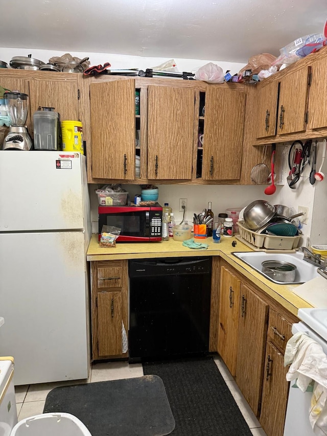 kitchen featuring light tile patterned flooring, black dishwasher, sink, white fridge, and stove