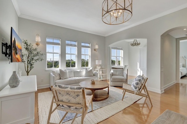 living room with a notable chandelier, a wealth of natural light, and light wood-type flooring