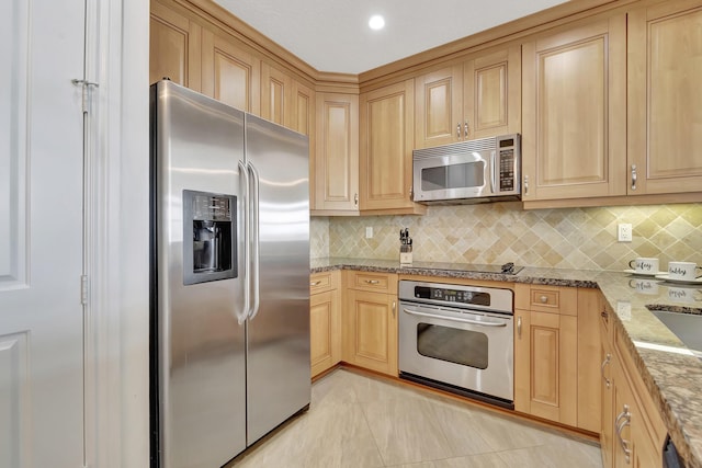 kitchen with tasteful backsplash, light stone countertops, light brown cabinets, and black appliances