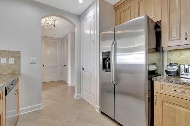 kitchen with tasteful backsplash, light stone counters, stainless steel appliances, and light brown cabinets