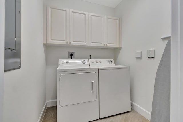 clothes washing area with washer and dryer and cabinets