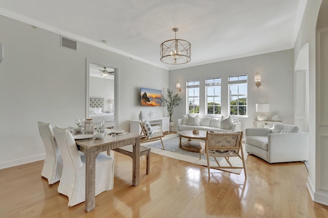 dining room featuring crown molding, a chandelier, and light hardwood / wood-style floors