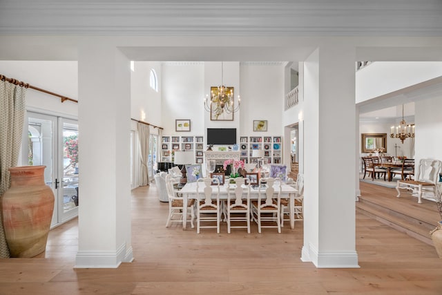 dining space featuring crown molding, a chandelier, and light hardwood / wood-style floors