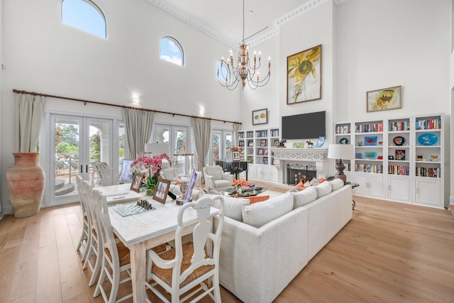 living room with french doors, an inviting chandelier, and light wood-type flooring