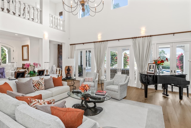 living room featuring french doors, a chandelier, and light hardwood / wood-style floors