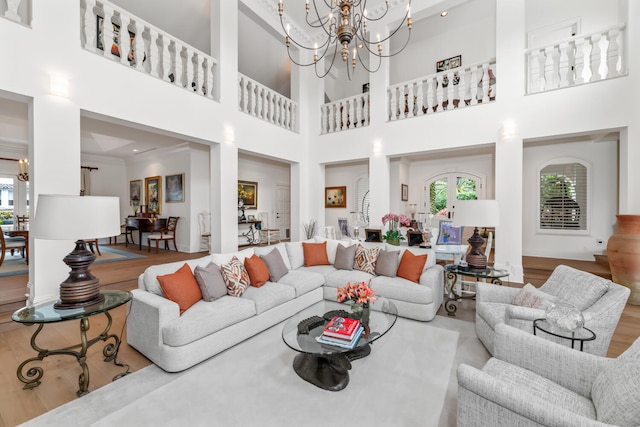 living room featuring an inviting chandelier, hardwood / wood-style flooring, and crown molding