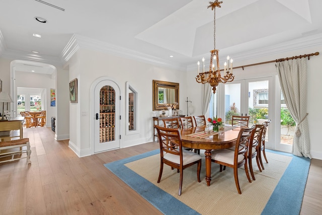 dining area featuring ornamental molding, light hardwood / wood-style floors, and a notable chandelier