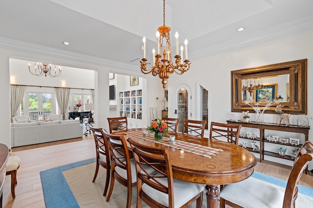 dining area featuring crown molding, light hardwood / wood-style flooring, french doors, and a chandelier