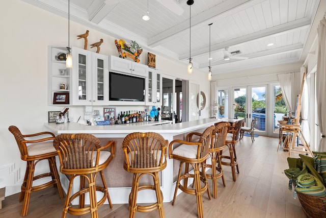 kitchen featuring pendant lighting, white cabinetry, beamed ceiling, and light wood-type flooring