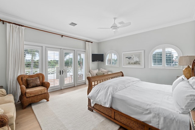 bedroom with crown molding, light hardwood / wood-style floors, multiple windows, and access to outside