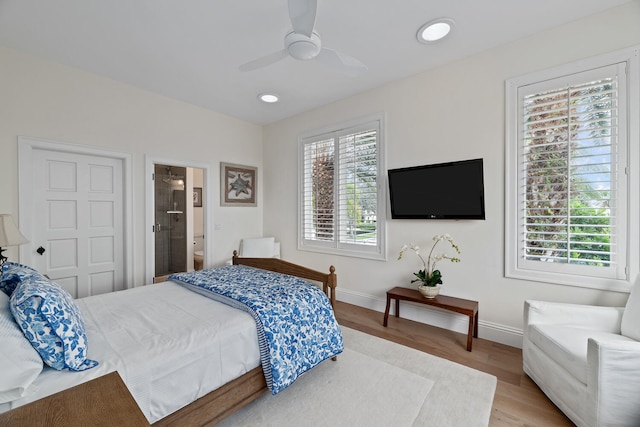 bedroom with connected bathroom, hardwood / wood-style flooring, and ceiling fan