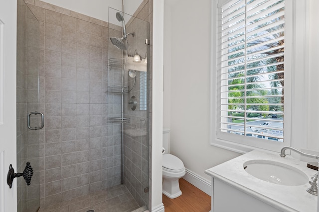 bathroom with vanity, toilet, hardwood / wood-style floors, and a shower with shower door