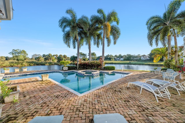 view of swimming pool featuring a patio area, a water view, and an in ground hot tub