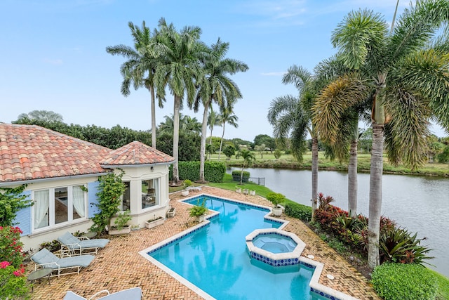 view of pool with a water view and an in ground hot tub