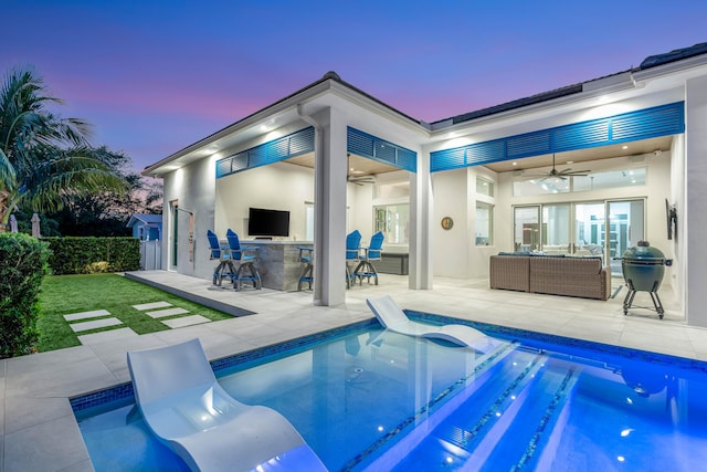 view of swimming pool featuring a patio, exterior bar, outdoor lounge area, ceiling fan, and a hot tub