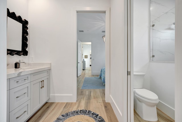 bathroom featuring walk in shower, wood-type flooring, toilet, and vanity