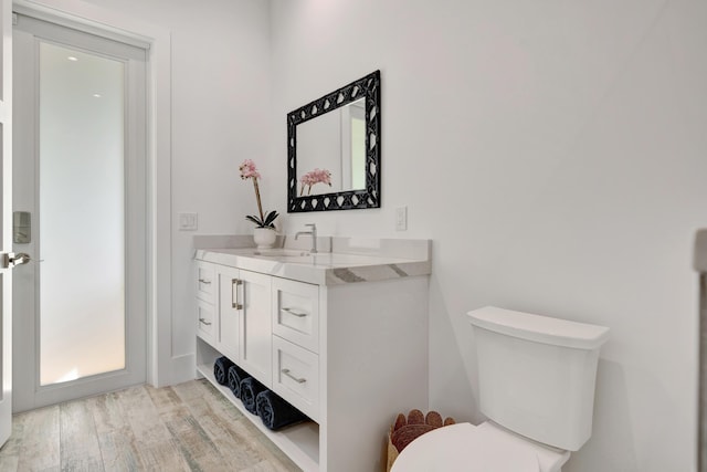 bathroom featuring vanity, hardwood / wood-style floors, and toilet