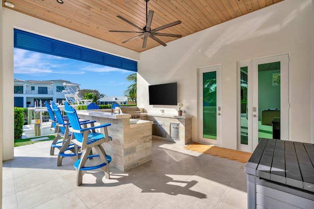 view of patio featuring a grill, area for grilling, ceiling fan, and a bar