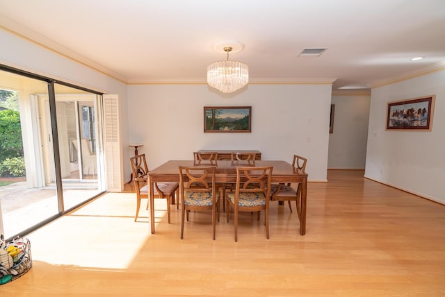 dining room with crown molding, light hardwood / wood-style flooring, and a notable chandelier