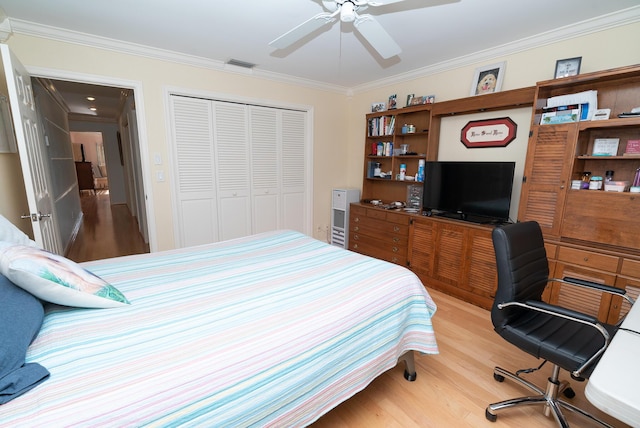 bedroom with crown molding, light hardwood / wood-style flooring, a closet, and ceiling fan