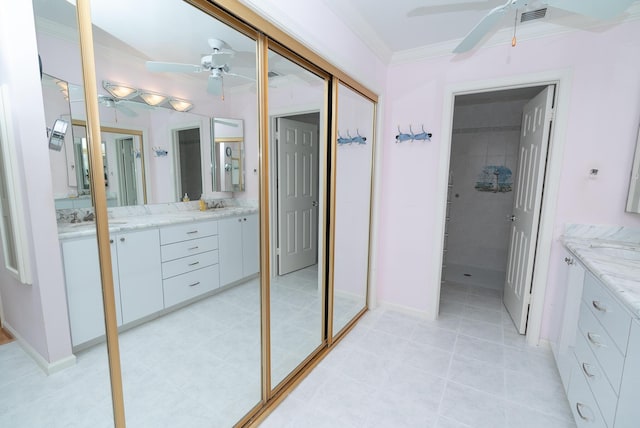 bathroom featuring ceiling fan, ornamental molding, and vanity