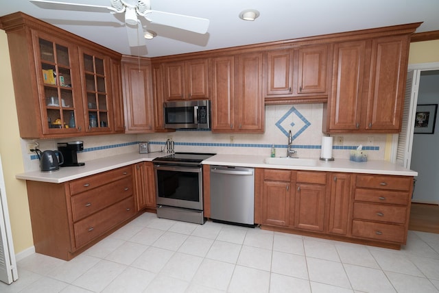 kitchen with appliances with stainless steel finishes, sink, backsplash, and ceiling fan