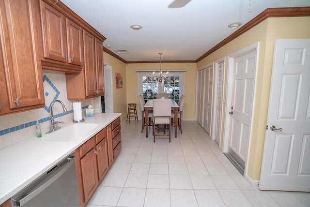 kitchen featuring sink, crown molding, stainless steel dishwasher, pendant lighting, and backsplash