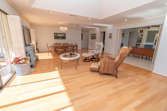 living room with ornamental molding and light hardwood / wood-style floors