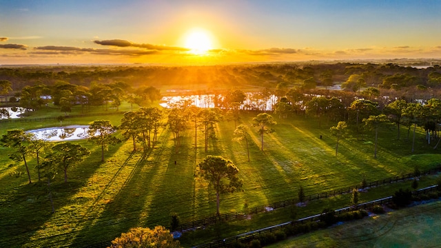 aerial view at dusk with a water view and a rural view