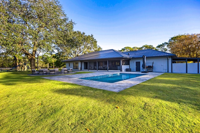 view of swimming pool featuring a lawn, a patio, and a playground