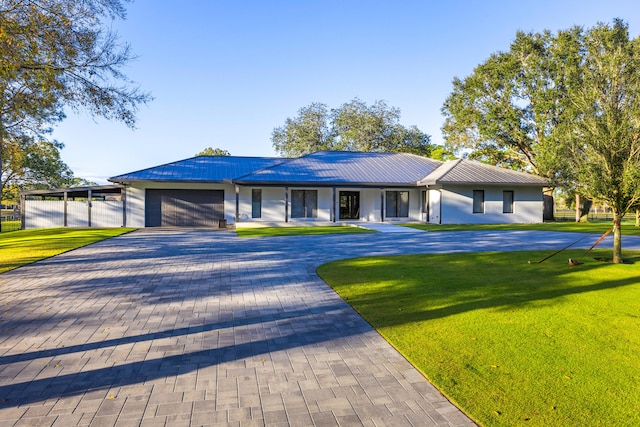 ranch-style house featuring a garage and a front lawn