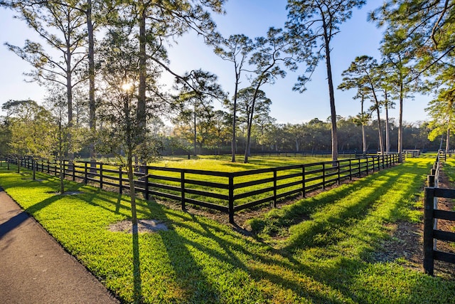 view of gate with a rural view and a lawn