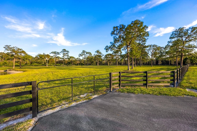 view of gate with a rural view and a yard