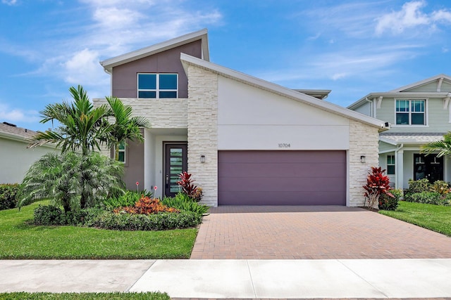 contemporary house featuring a garage and a front lawn