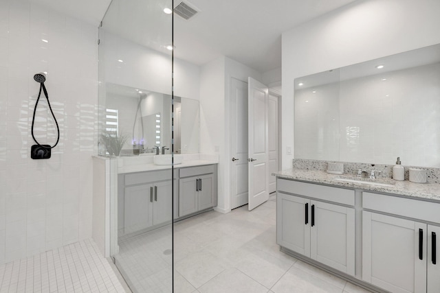 bathroom with vanity and tiled shower