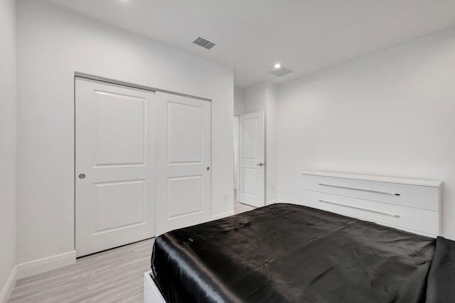 bedroom with light hardwood / wood-style floors and a closet