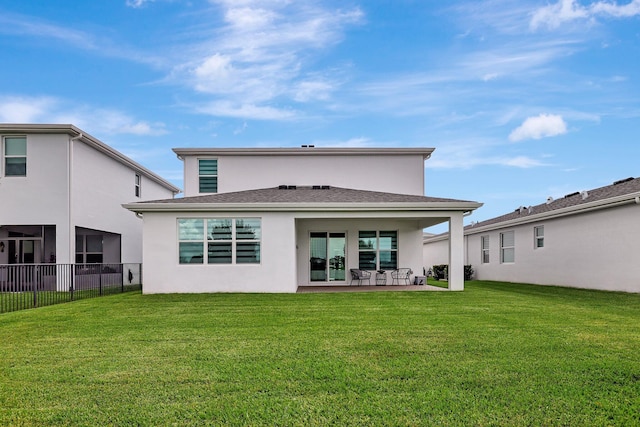 back of property with a lawn and a patio area