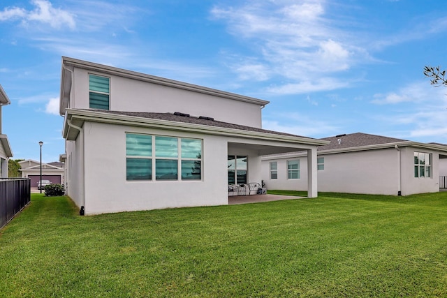 rear view of property with a yard and a patio area