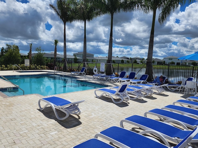 view of pool featuring a patio area and a water view