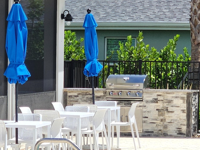 view of patio with exterior kitchen, area for grilling, and a bar