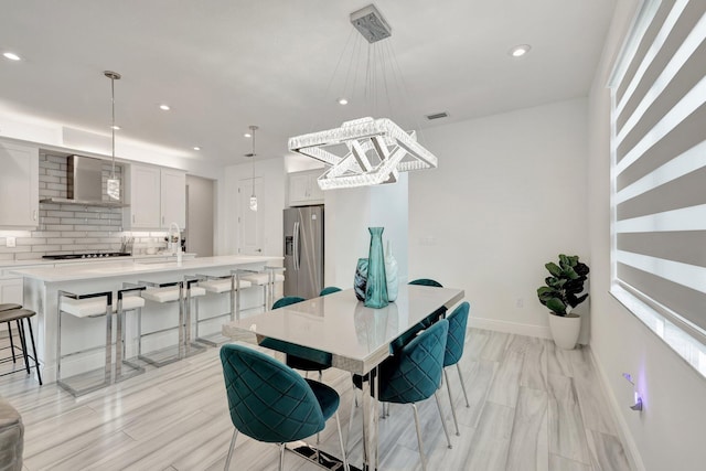 dining area with sink and light hardwood / wood-style floors