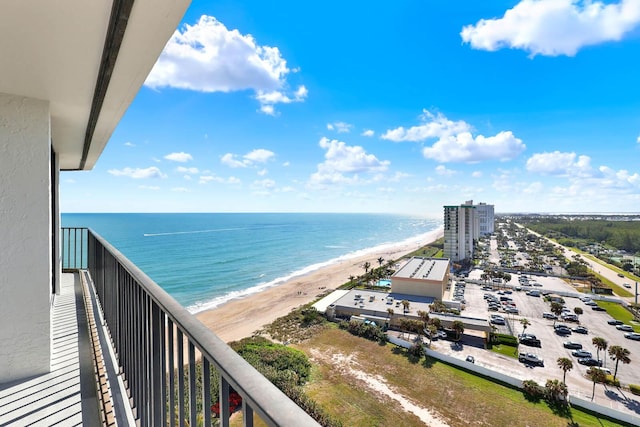 balcony featuring a view of the beach and a water view