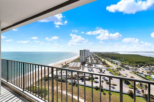 balcony featuring a beach view and a water view