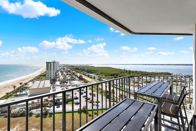 balcony featuring a water view and a beach view