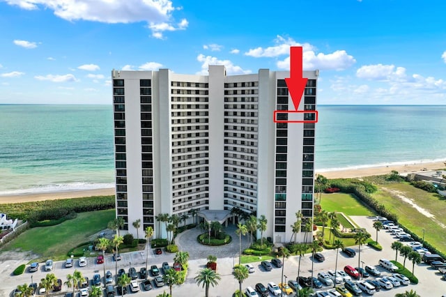 view of property with a water view and a beach view